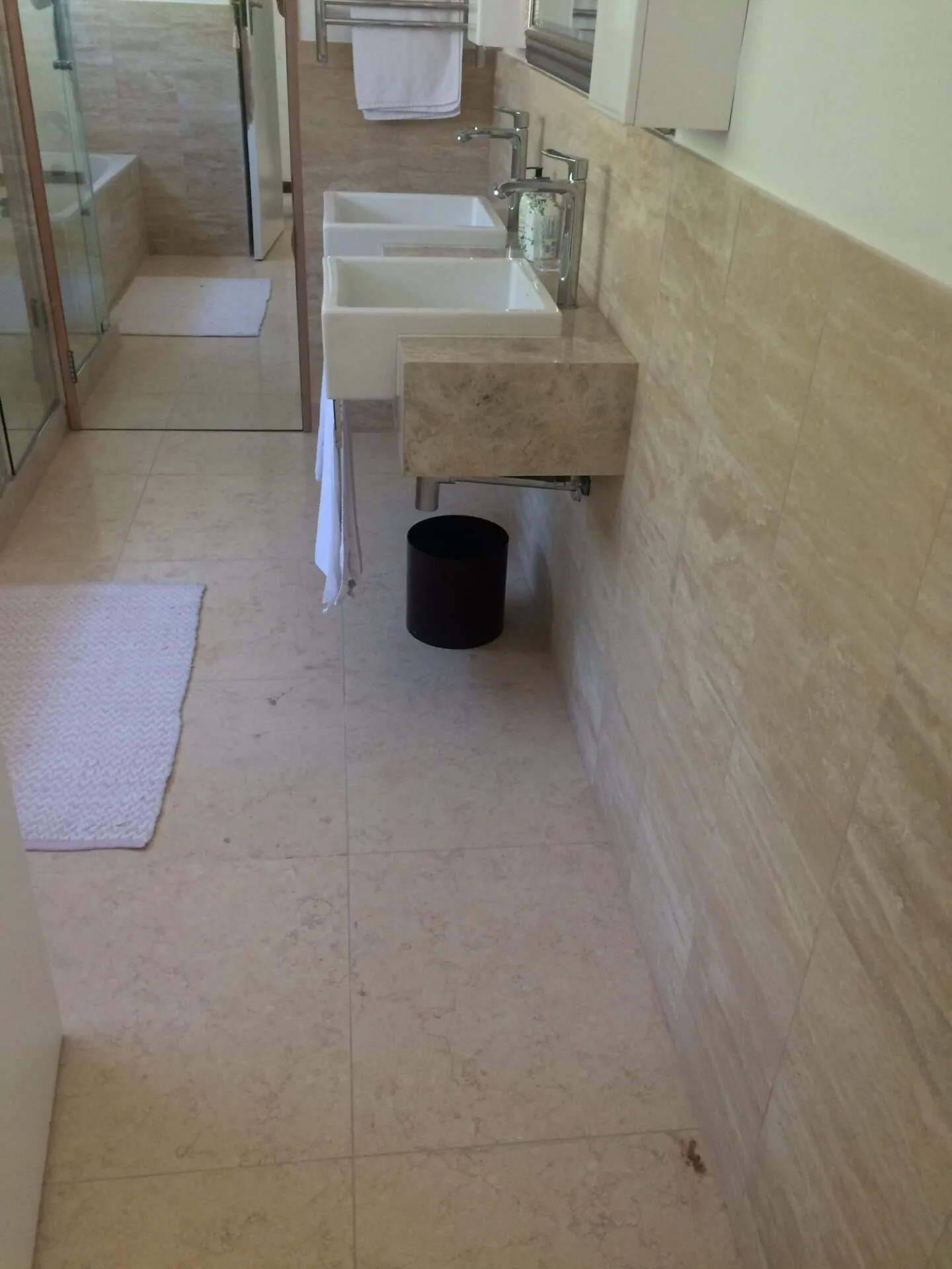 A bathroom vanity with a stone counter and under-counter storage.