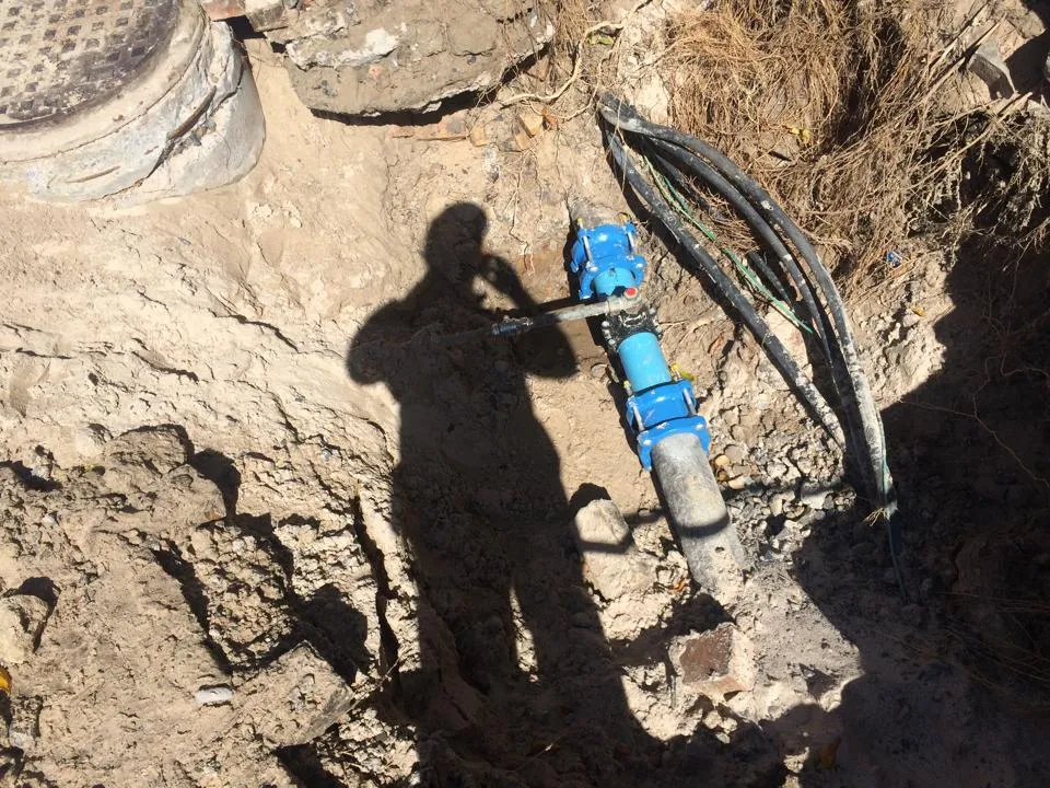 Deep excavation exposing a water main under repair.