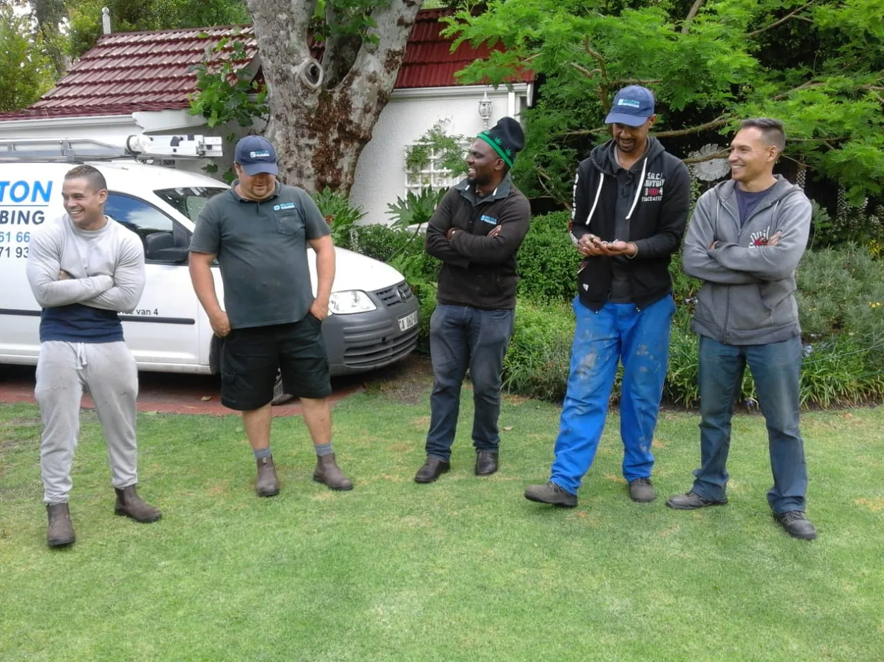 Wilton Plumbing team members standing beside a company van.