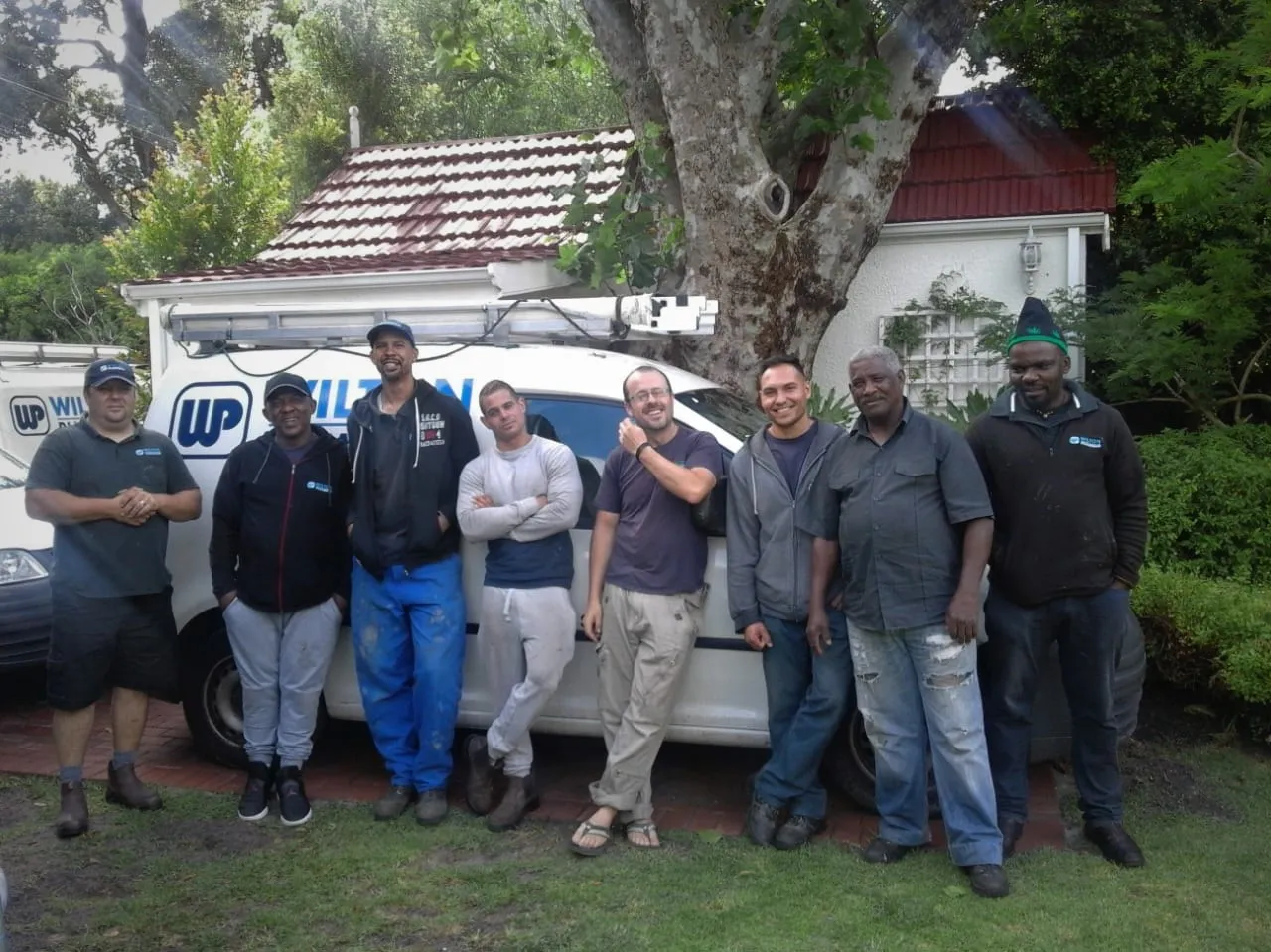 Wilton Plumbing team members standing in front of the company vans.